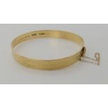 A 9ct gold bangle with bright engraved finish, inner diameter approx 5.5cm, weight 13.2gms Condition
