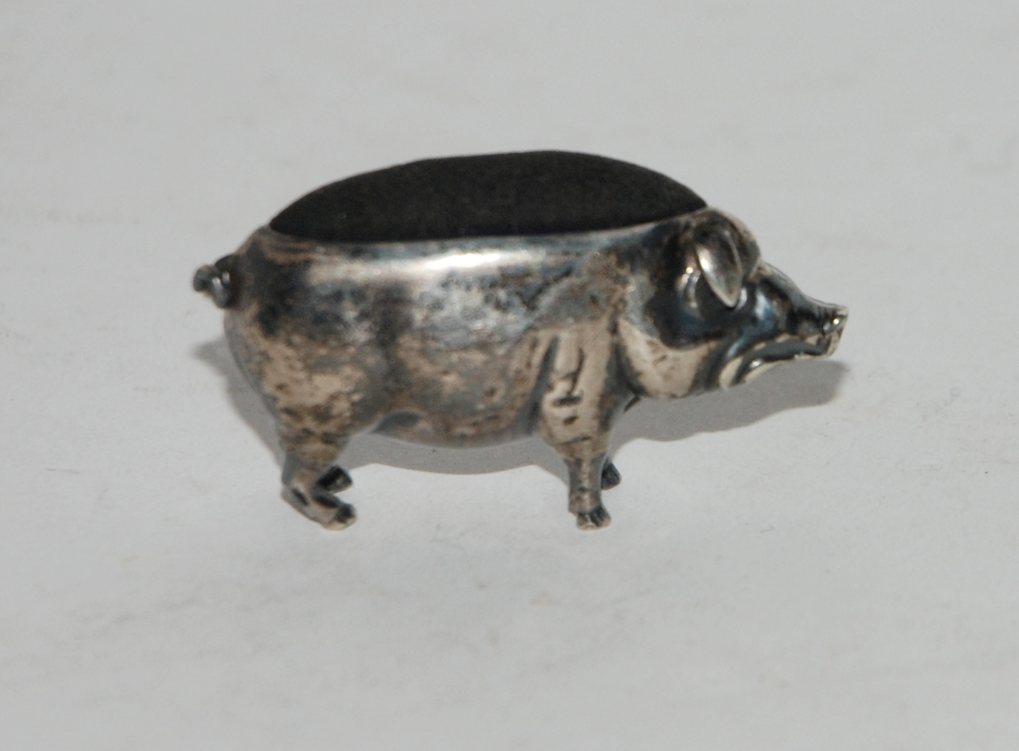 A novelty silver pin cushion modelled as a pig, Birmingham 1905, 4.5cm long Condition Report: