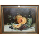 E PETIT Still life with wine bottle and fruit, signed, oil on board, 49 x 64cm Condition Report: