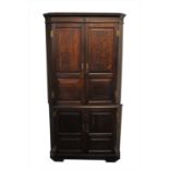 A large George III free-standing two sectional corner cupboard