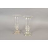 A pair of tall clear cut glass storm lanterns and a bronzed figural table lamp