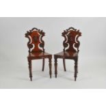 A pair of Victorian mahogany hall chairs