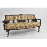 A Victorian upholstered mahogany framed kidney shaped settee
