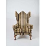 An early 20th century wing armchair with cabriole legs terminating in club feet