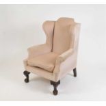 A large and heavy Queen Ann style upholstered wing-back arm chair