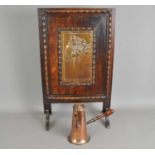 An oak framed continental fire screen and a Victorian copper chocolate pot