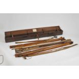 A large early 20th century hinged pine rod case containing several fishing rods