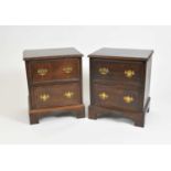 A pair of country oak bedside chests of two drawers