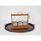 A Victorian three-bottle oak tantalus with three later decanters and a mahogany butler's tray