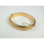 A 9ct gold hinged bangle