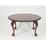 A Victorian mahogany dining table, the extending top with carved border, raised on tapering claw and