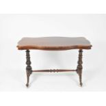 A victorian rosewood centre table, with shaped bevelled top over carved legs and castors united by a