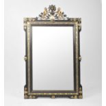 A large, decorative wall mirror, with a blackened and gilt frame surmounted with a pair of cherubs