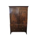 A 19th century mahogany linen press, the hinged panelled doors opening to reveal sliding drawers,
