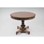 A 19th century carved rosewood tilt-top centre table, the circular top with a foliate carved