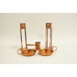 A pair of decorative copper candlesticks, in the Arts & Crafts style, after Rennie Mackintosh,