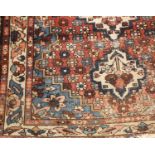 A small old Eastern woven wool rug, decorated with flowers and central medallions, 144 x 210cm