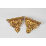 A pair of carved gilt wooden wall sconces, with symmetrical foliate motifs 21cm high, 22 x 12.5cm.