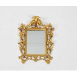 A small late 19th/early 20th century Florentine style gilt carved wood wall mirror, with scrolling