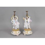 A pair of French bisque candleholders and associated stands