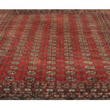 A red ground Aghan woven wool rug, with multi-medallion field set within geometric borders, 302 x