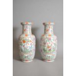 A pair of Chinese porcelain famille rose turquoise ground baluster vases, Qing dynasty