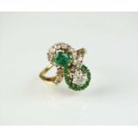 A diamond and emerald cross over ring