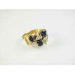An 18ct gold sapphire and diamond ring in the style of Andrew Grima