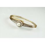 A late 19th century untested pearl and diamond hinged bangle
