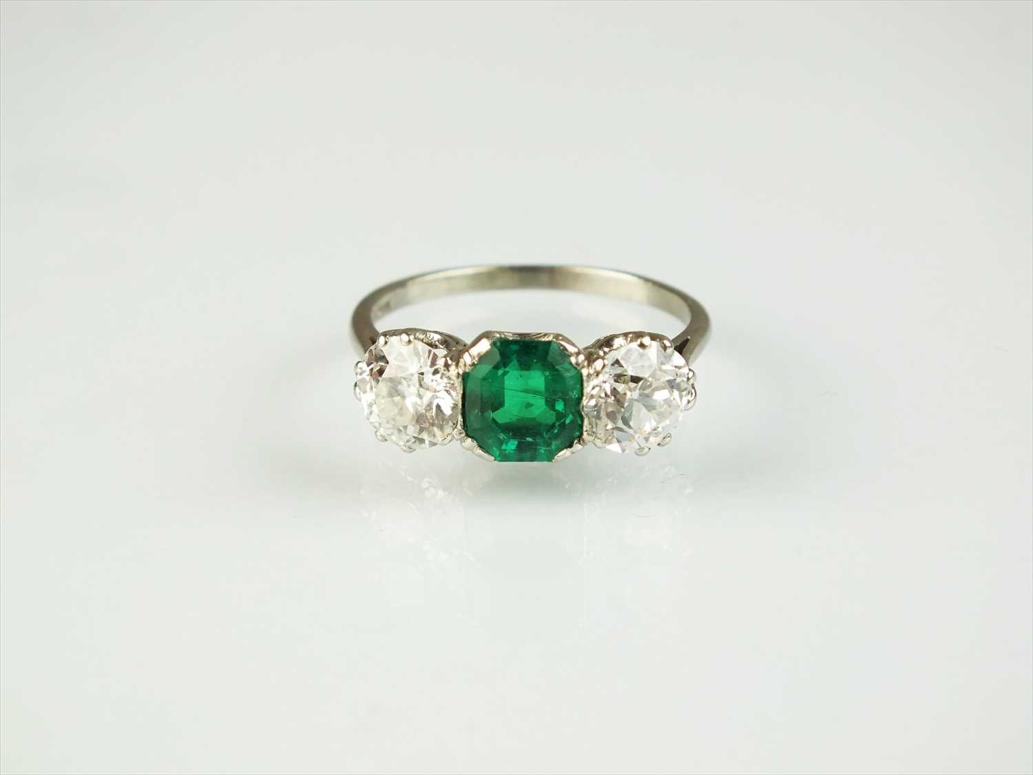 A three stone emerald and diamond ring