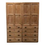 A pair of tall pale stripped pine hall cupboards