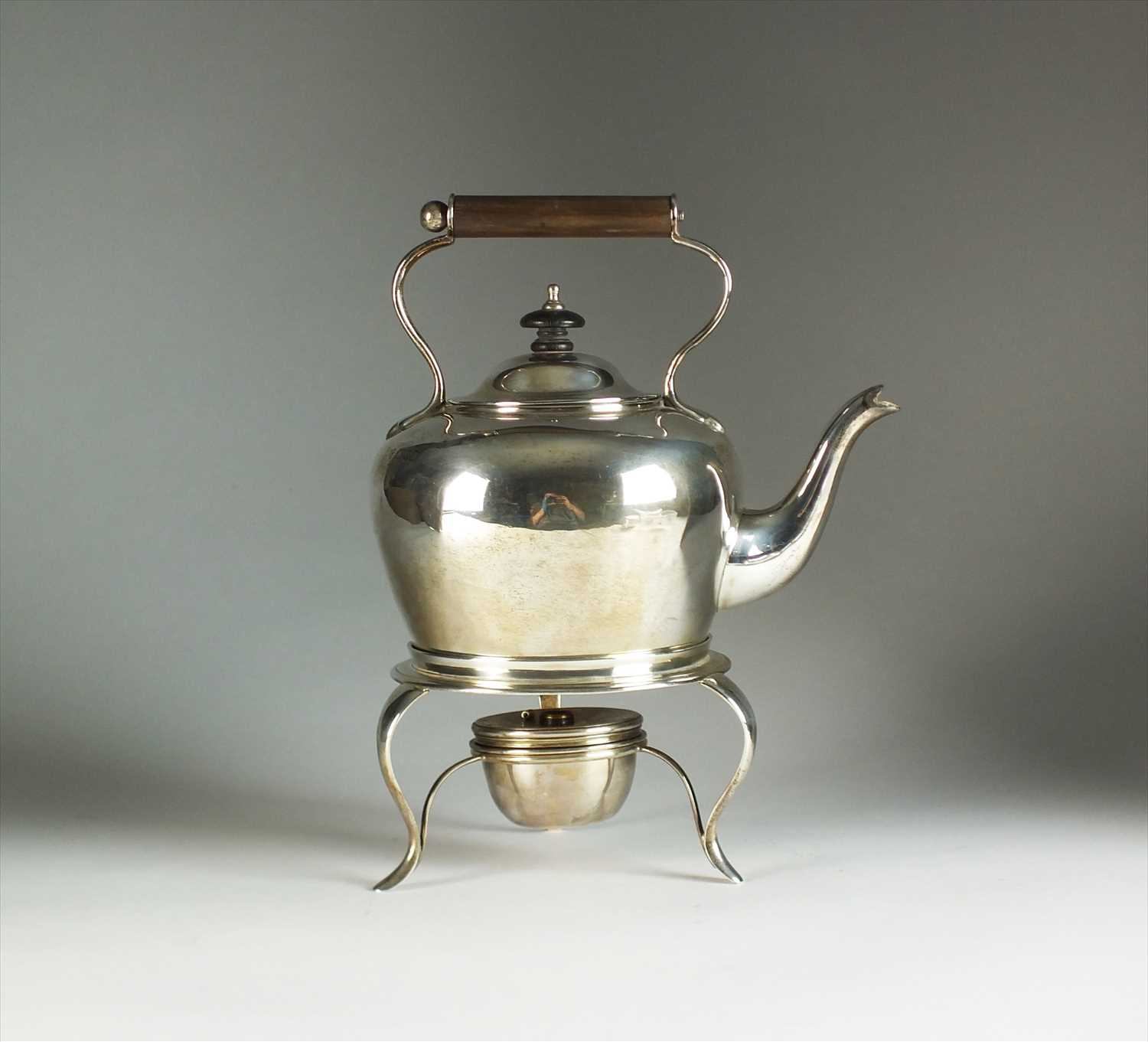 A silver kettle on stand with burner