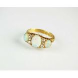 An Edwardian nine stone opal and diamond ring