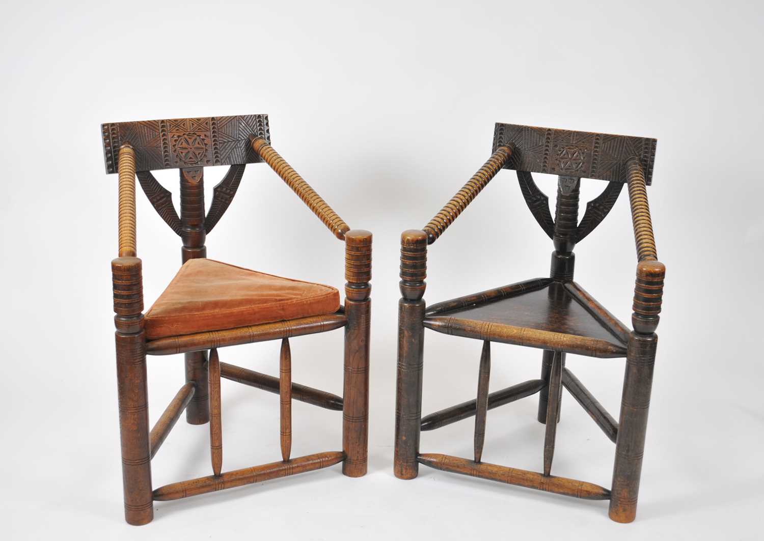 A pair of Victorian oak turners chairs, each with a chip carved back rail and supports, ring