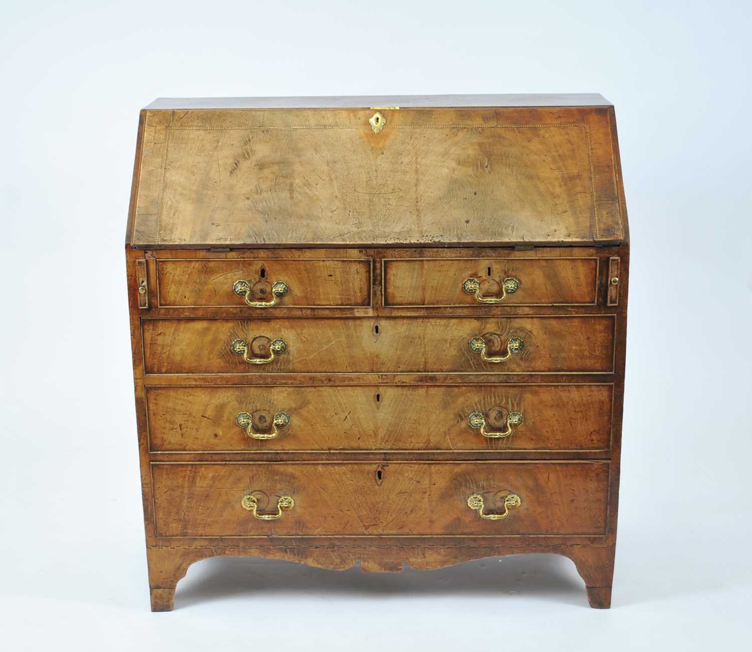 An early George III walnut and mahogany bureau, the figured fall with chequered stringing and a