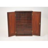 An early 19th century mahogany collectors cabinet, with two panelled doors, enclosing 49 graduated