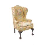 An early 20th century, George II style, wing armchair of generous proportions, the cabriole legs