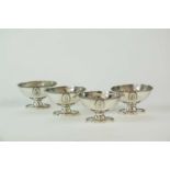 A set of four white metal pedestal salts