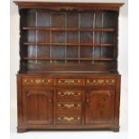 A George III oak dresser with rack, North Wales, the later three tier rack above a base with three