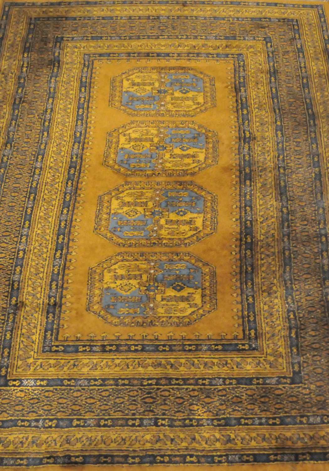 A Turkoman style rug, the central panel with four guhls on a beige ground, within floral and