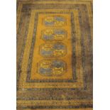A Turkoman style rug, the central panel with four guhls on a beige ground, within floral and