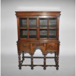 A c1700 and later oak cabinet on an associated stand with three frieze drawers above a shaped apron,