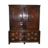 An early 18th century oak livery cupboard, the cyma recta cornice above two large arched fielded