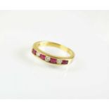 An 18ct gold seven stone ruby and diamond half eternity ring