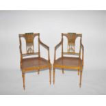 A pair of George III style painted satin birch elbow chairs, circa 1900, decorated in the Adam style