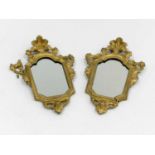 A pair of 19th century Italian, gilded wall mirrors, of cartouche form, each base with a moulded