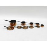 A graduated harlequin, or composite, set of 5, late 19th/early 20th century copper saucepans, the