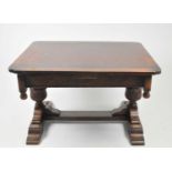A heavy oak draw-leaf dining table, with rounded corners and carved borders, raised on a heavy