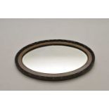 An oval wall mirror with moulded frame and bevelled plate, 64 x 86cm (maximum).