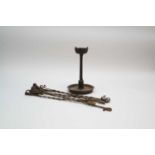 An early cast iron whale oil lamp, witrh a circular tray base, 29cm high, together with wrought iron